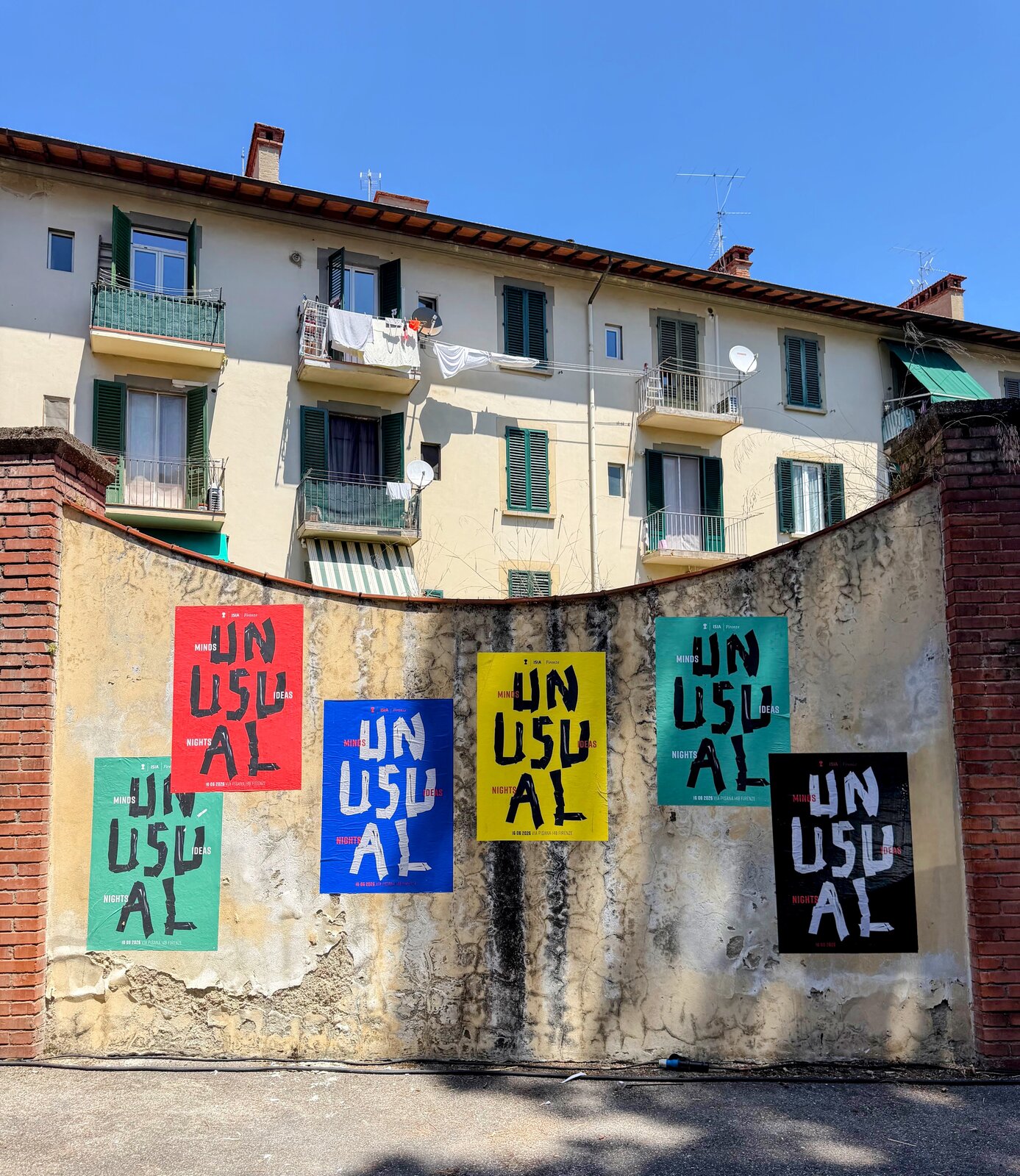 Színes UNUSUAL — Minds, Ideas, Nights plakátok egy falon az ISIA Firenze helyszíne előtt